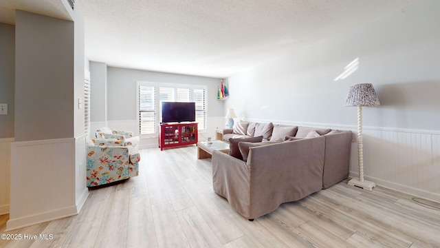 living room featuring light hardwood / wood-style floors and a textured ceiling