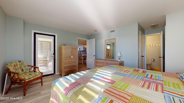 bedroom featuring ensuite bath, light hardwood / wood-style floors, and access to exterior