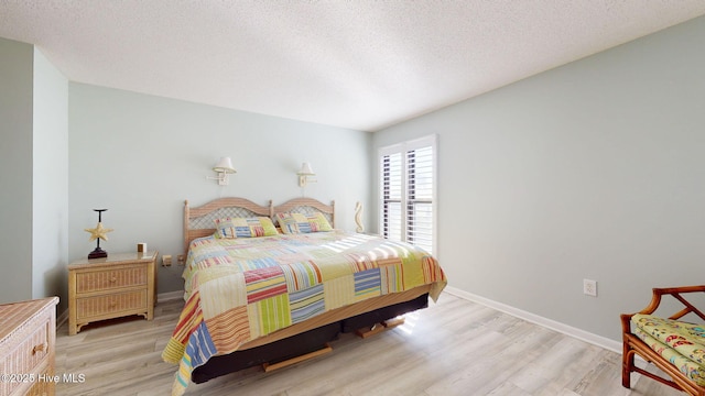 bedroom with a textured ceiling and light wood-type flooring