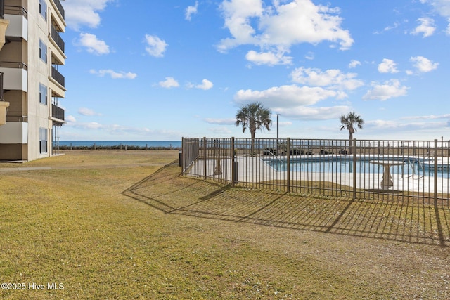 view of swimming pool featuring a yard and a water view