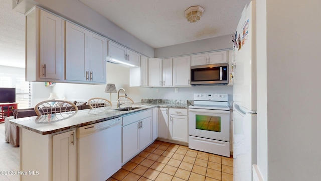 kitchen featuring sink, white cabinets, white appliances, and light tile patterned floors