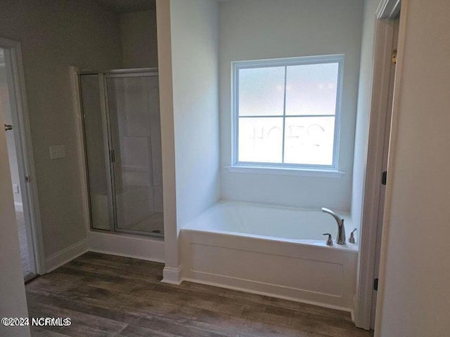 bathroom with independent shower and bath and wood-type flooring