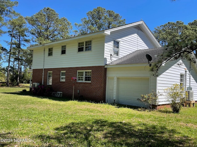 back of property with a garage and a yard