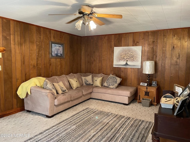 carpeted living room with wood walls and ceiling fan