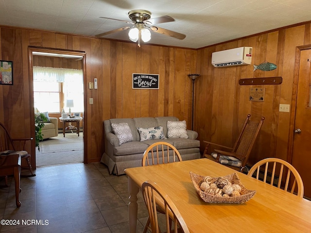 dining area with wooden walls, an AC wall unit, tile floors, and ceiling fan