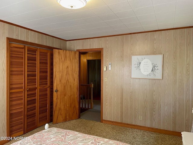 unfurnished bedroom featuring carpet flooring, crown molding, and a closet