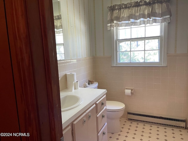 bathroom with tile walls, a baseboard radiator, tile floors, toilet, and vanity