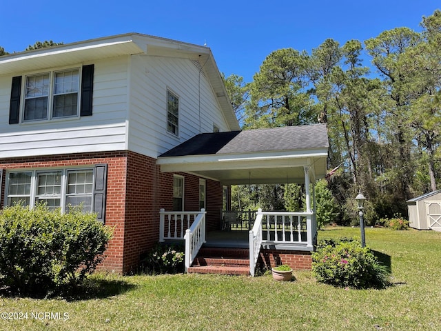 view of front facade with a storage shed and a front lawn