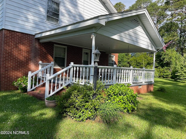 exterior space featuring covered porch and a yard