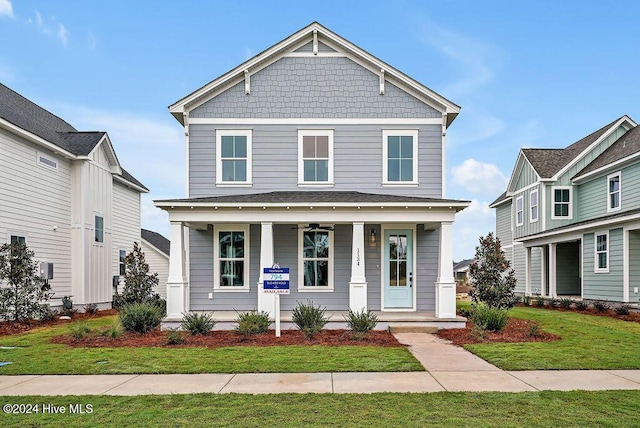 view of front of house featuring covered porch, a front lawn, and a balcony