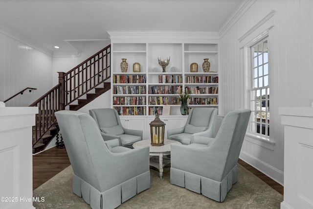 living area featuring hardwood / wood-style floors and crown molding