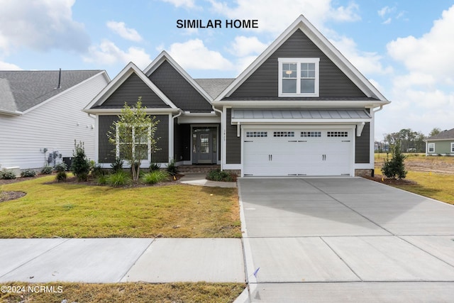 craftsman house featuring a garage and a front lawn