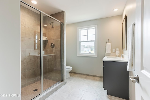 bathroom with walk in shower, large vanity, toilet, and tile flooring