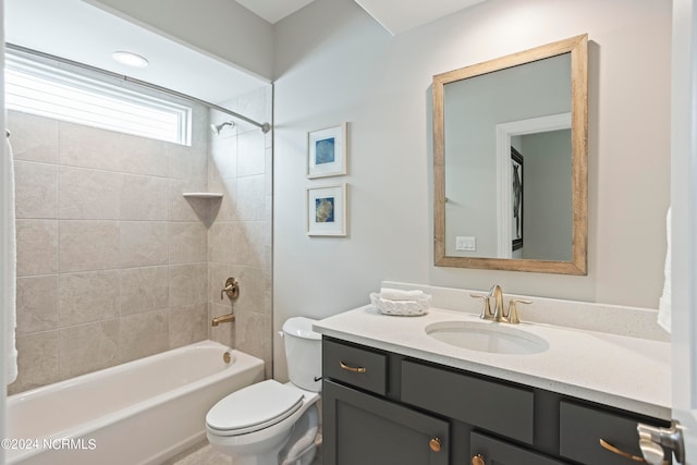 full bathroom with tiled shower / bath, toilet, and vanity