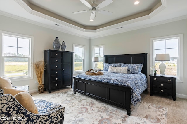 carpeted bedroom featuring ornamental molding, ceiling fan, and a tray ceiling