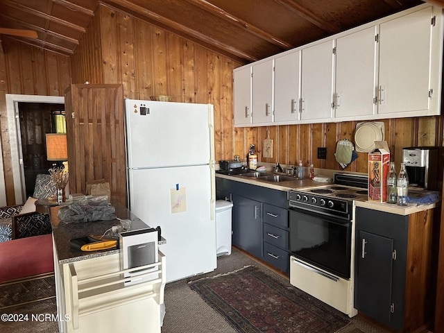 kitchen featuring dark carpet, wooden walls, white cabinets, and white appliances