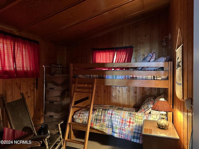 carpeted bedroom with wooden walls and lofted ceiling