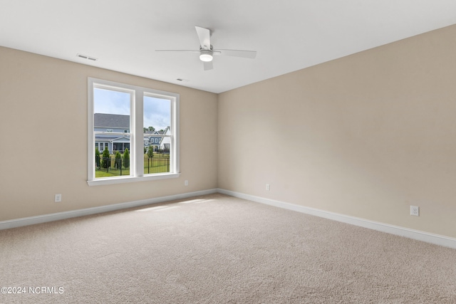 unfurnished room featuring carpet flooring, ceiling fan, baseboards, and visible vents