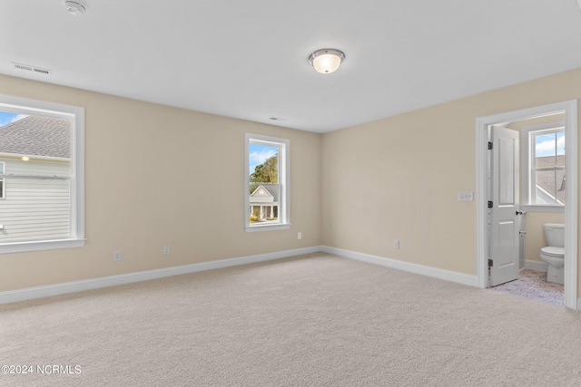 unfurnished bedroom featuring visible vents, baseboards, carpet, and connected bathroom