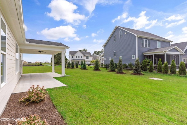 view of yard with a patio, a sunroom, and ceiling fan