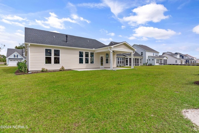 back of house featuring a lawn, ceiling fan, and a patio area