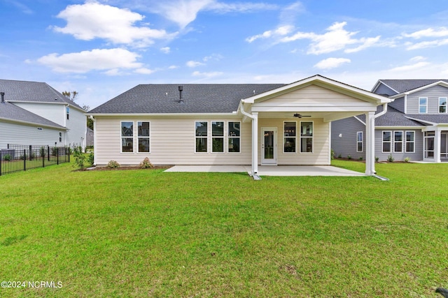 rear view of property featuring a patio, a lawn, ceiling fan, and fence