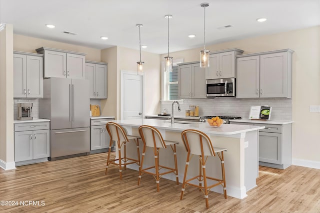 kitchen featuring a sink, gray cabinetry, light wood-type flooring, and stainless steel appliances