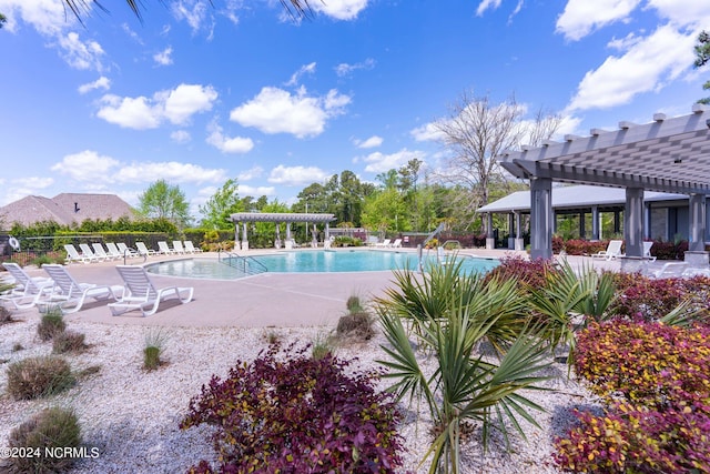 community pool with a patio, fence, and a pergola