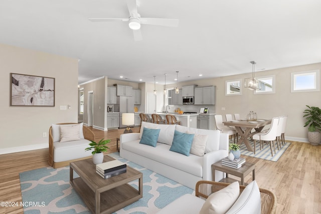 living area with recessed lighting, light wood-type flooring, baseboards, and ceiling fan