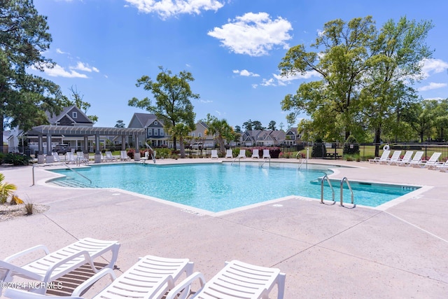 community pool with a patio, fence, and a pergola