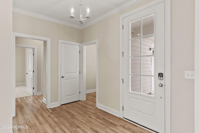 foyer entrance featuring baseboards, light wood-style floors, an inviting chandelier, and ornamental molding