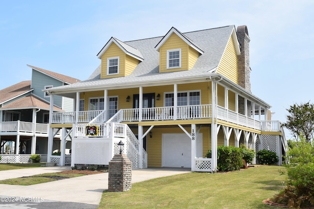 view of front of house with covered porch, a garage, and a front yard