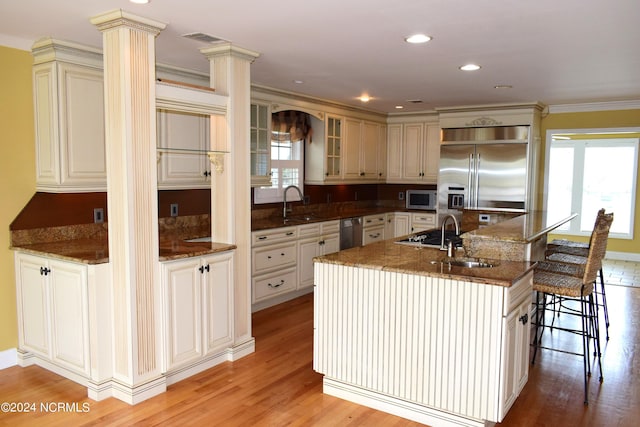 kitchen with plenty of natural light, a spacious island, light wood-type flooring, and appliances with stainless steel finishes