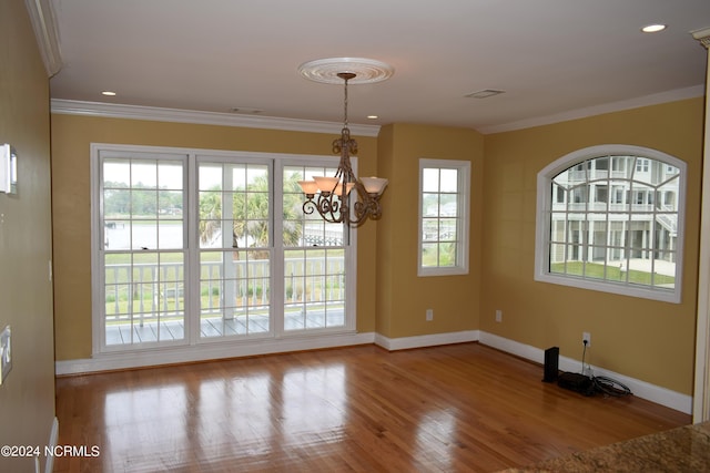 unfurnished dining area featuring a notable chandelier, light hardwood / wood-style floors, and ornamental molding