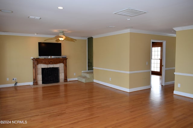 unfurnished living room with a fireplace, light hardwood / wood-style flooring, ceiling fan, and ornamental molding