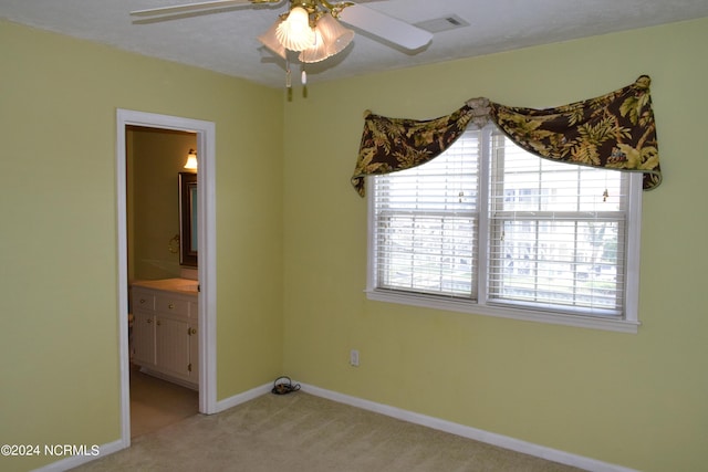 carpeted spare room featuring ceiling fan