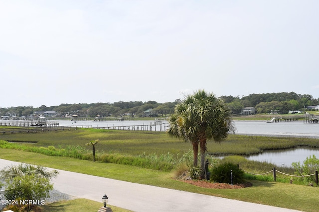 surrounding community with a lawn and a water view