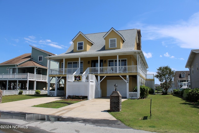 view of front facade featuring covered porch, a garage, and a front yard