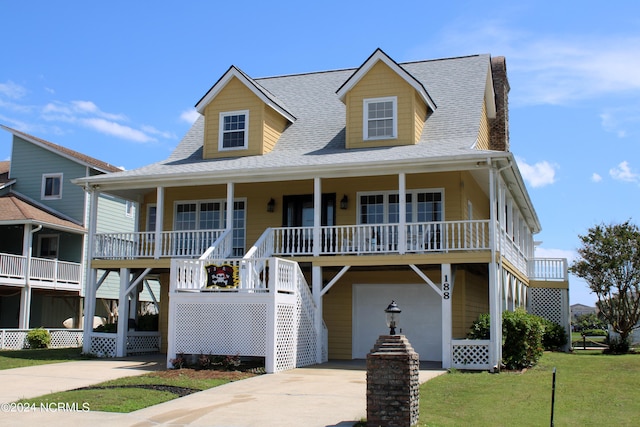 beach home with a garage, covered porch, and a front yard