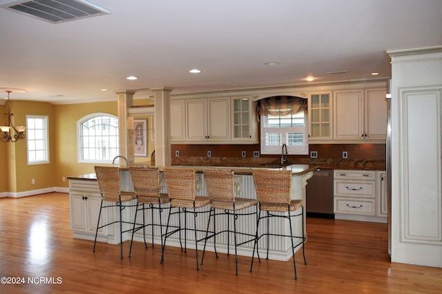 kitchen featuring dishwasher, light hardwood / wood-style floors, a kitchen island, and a chandelier