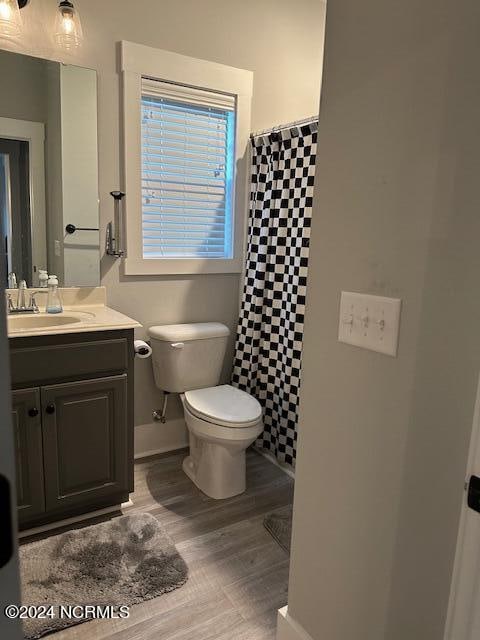 bathroom featuring tile walls, oversized vanity, hardwood / wood-style flooring, and toilet