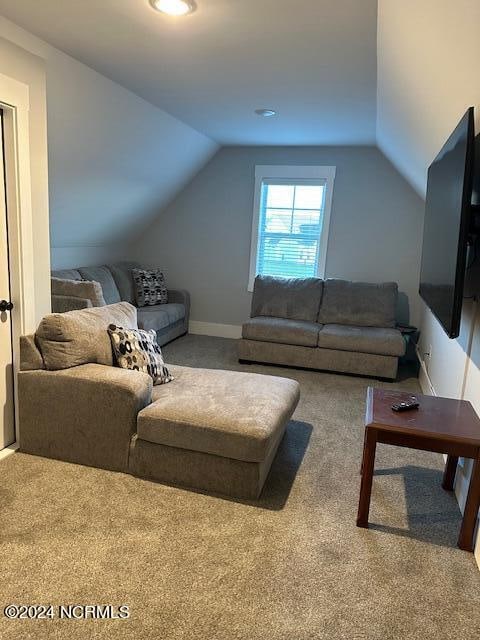 carpeted living room featuring vaulted ceiling