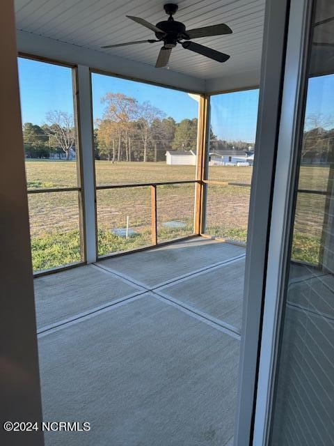 unfurnished sunroom with ceiling fan