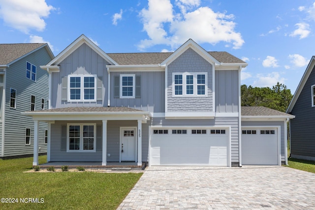 view of front of property with a porch, a garage, and a front yard