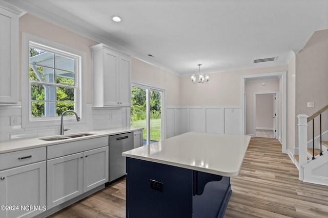 kitchen featuring a center island, light hardwood / wood-style floors, stainless steel dishwasher, and a healthy amount of sunlight