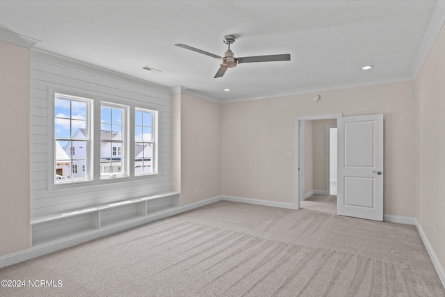 carpeted empty room featuring ceiling fan and ornamental molding