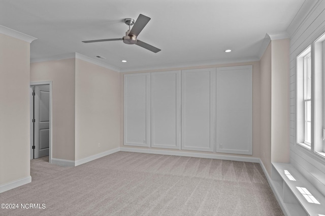 empty room with light colored carpet, ceiling fan, and ornamental molding