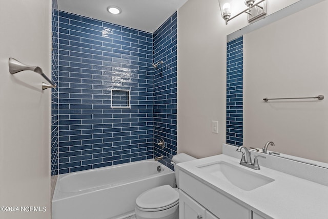 full bathroom featuring vanity, tiled shower / bath combo, and toilet