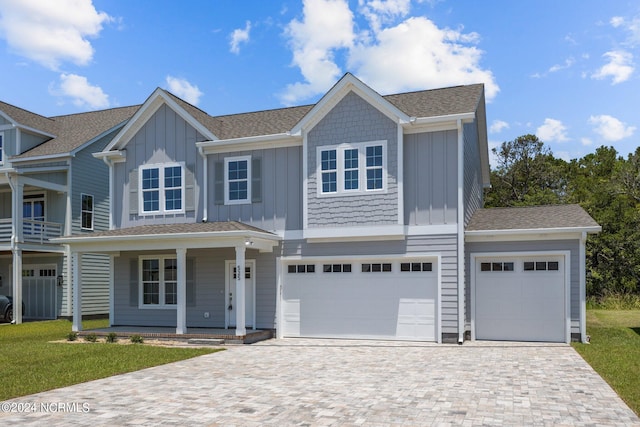 view of front of home with a front lawn, covered porch, and a garage