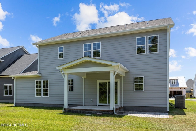 back of property featuring central AC unit, a patio area, and a lawn